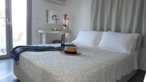 un chapeau posé sur un lit dans une chambre dans l'établissement Niovi, à Fira