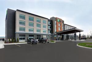 a building with a car parked in a parking lot at Holiday Inn Express & Suites - Collingwood in Collingwood