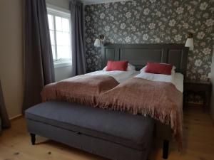 um quarto com uma cama grande e almofadas vermelhas em Sanner Hotell em Gran