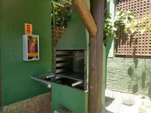 un horno verde en el lateral de un edificio en Pousada Vale Verde Bungalows, en Praia do Rosa