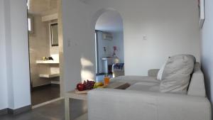 - un salon avec un canapé et une table avec des fruits dans l'établissement Niovi, à Fira