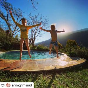 two young children jumping into a swimming pool at Frog Mountain Getaway in Swellendam