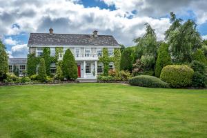 a large white house with a large yard at Tattykeel House in Omagh