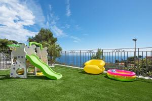 un parque infantil con 2 toboganes y un frisbee en Luxury Bicocca, en Costarainera