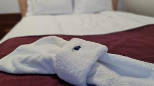 a white towel is sitting on a bed at Borovnica Sweet Apartments in Žabljak