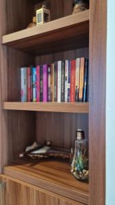 a book shelf with books and a glass jar on it at Borovnica Sweet Apartments in Žabljak