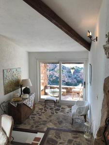 un soggiorno con una grande porta a vetri che conduce a un patio di Villa La Cuata a Costa Paradiso