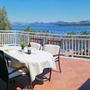 a table on a balcony with a view of the water at Holiday Home Blue Dream in Putniković