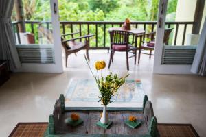 a vase with flowers on a table on a porch at Surya Shanti Villa Sidemen in Sidemen