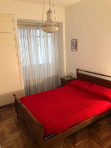 una camera con letto rosso e finestra di Excelente depto. para 5 personas. Zona ideal !! a Mar del Plata