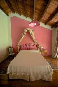 a bedroom with a bed with a pink wall at Agrimargherita in Caorle