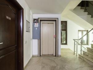 un pasillo con una puerta y escaleras en una casa en Hotel Jashn Inn near Apollo Hospital, en Nueva Delhi