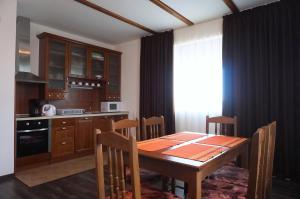 a kitchen with a wooden table and a dining room at Вила Едем - Villa Edem - Beach Bolata Area in Bŭlgarevo