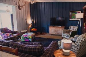 a living room with couches and a tv at The Cabin - Luxury Country Living in Cullybackey