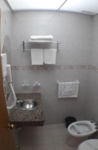 ein Bad mit einem Waschbecken, einem WC und Handtüchern in der Unterkunft KRAKUS in San Bernardo