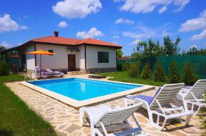 uma piscina com cadeiras e uma casa em Вила Едем - Villa Edem - Beach Bolata Area em Bulgarevo