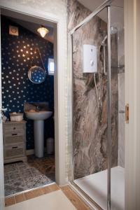 ein Bad mit einer Dusche und einem Waschbecken in der Unterkunft The Cabin - Luxury Country Living in Cullybackey