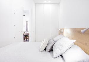マドリードにあるMalasaña Apartment by Flatsweethomeの白いベッドルーム(白い枕付きのベッド1台付)
