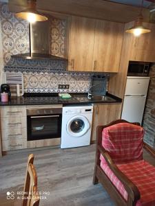 a kitchen with a stove and a washing machine at La Catalpa in Arasán