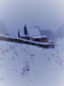 a house in a field covered in snow at Mäcky Baude in Dippoldiswalde