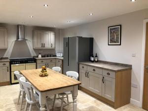 a kitchen with a wooden table and a refrigerator at Sunnyside Cottage in Sleaford