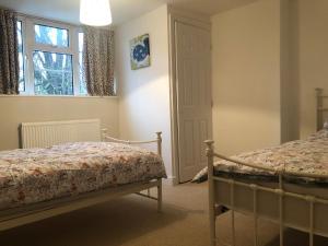 a bedroom with two beds and a window at Sunnyside Cottage in Sleaford