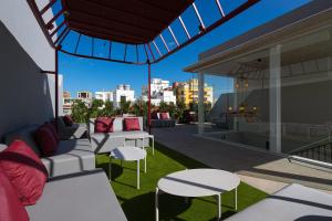 - un balcon avec un canapé et des tables dans un bâtiment dans l'établissement Boutique Hotel Cordial Malteses, à Las Palmas de Gran Canaria