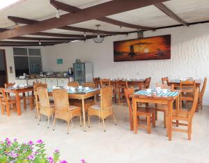 a dining room with wooden tables and chairs at Hotel Coral Blanco with high speed internet Starlink in Puerto Villamil