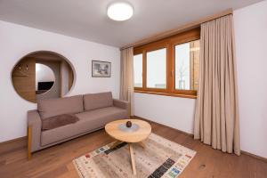 - un salon avec un canapé et une table dans l'établissement Apartments Bergleben Goldegg, à Goldegg