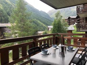 a table on a balcony with a view of a mountain at Au Pied des Pistes B 04 in Grimentz