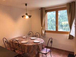 a dining room table with chairs and a window at Au Pied des Pistes B 04 in Grimentz