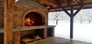 a brick fireplace with a fire in it at Apartments Woodnotes in Ličko Petrovo Selo