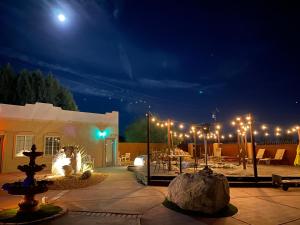 un patio con una fuente y luces por la noche en MI KASA HOT SPRINGS 420,Adults Only, Clothing Optional, en Desert Hot Springs