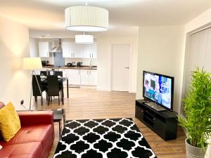a living room with a couch and a tv at Kings Chambers Apartments Coventry City Centre in Coventry