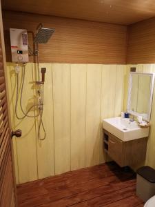 a bathroom with a sink and a shower at Kodaun River Kwai Resort in Kanchanaburi