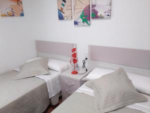 um quarto com 2 camas e um candeeiro numa mesa de cabeceira em Casas del Mar em Les Cases d'Alcanar