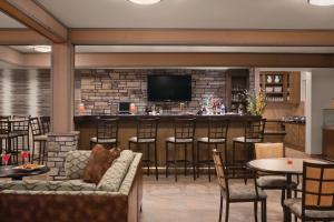 a bar in a restaurant with a couch and chairs at Hyatt House Minot- North Dakota in Minot