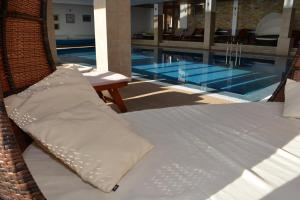 ein Korbbett neben einem Pool in der Unterkunft Apartman K5 Milmari Resort in Kopaonik