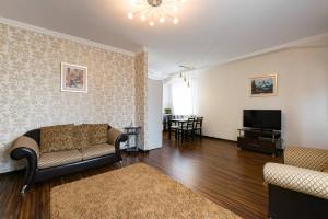 a living room with a couch and a television at Nadezhda Apartments on Keremet street in Almaty