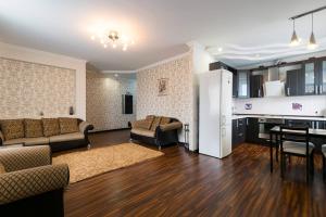 uma sala de estar com um sofá, uma mesa e uma cozinha em Nadezhda Apartments on Keremet street em Almaty