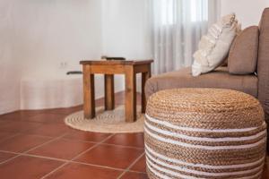 ein Wohnzimmer mit einem Sofa und einem Tisch in der Unterkunft Habitaciones y Apartamentos en el centro La Jábega by Conil Home in Conil de la Frontera