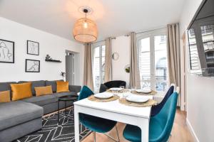 - un salon avec un canapé, une table et des chaises dans l'établissement Superbe appartement 6P rue des Martyrs, à Paris