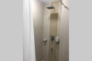 a bathroom with a shower with a white shower curtain at A blissful staycation in Tagaytay +9 photos