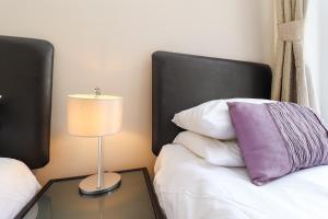 a bedroom with a bed and a table with a lamp at Eastbourne Sea View Apartment in Eastbourne