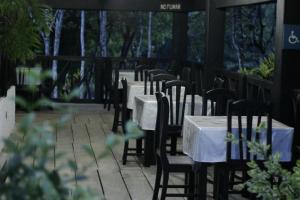 a patio area with tables, chairs and umbrellas at Ecolodge Las Nubes Chiapas in La Fortuna Gallo Giro