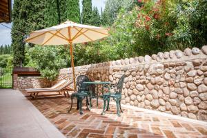 una mesa y sillas con una sombrilla en el patio en Villa Cordevigo, en Cavaion Veronese