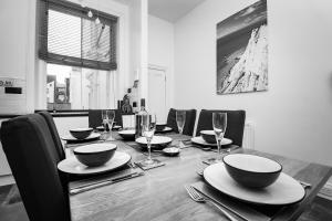 a dining room table with bowls and plates and wine glasses at Eastbourne Sea View Apartment in Eastbourne