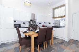 a kitchen with a wooden table and chairs at Eastbourne Sea View Apartment in Eastbourne