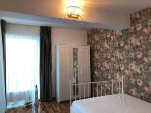 sypialnia z łóżkiem i kwiatową ścianą w obiekcie Piano Bar Holidays Apartments w Mamai