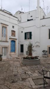 a white building with a blue door and a bench at Monolocale ad un passo dalla chiesa del Carmine in Martina Franca
